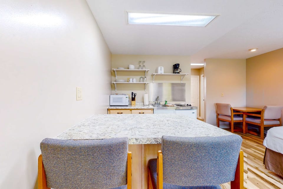 Dining bar with stools and spacious countertop. Great for breakfast, laptops, and game nights; ideal for couples, families, and long stays with kitchenette + fast, convenient setup.