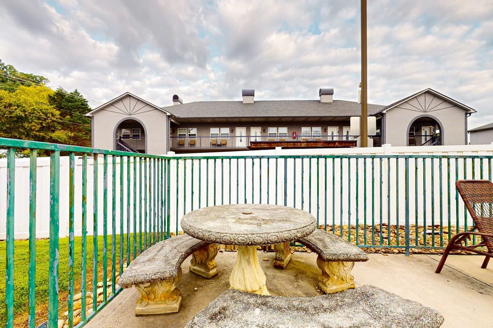 Outdoor patio picnic table by the pool area, and enjoy al fresco meals at this cozy condo with a shared poolside seating, fresh air, and scenic views; great for family trips, weekend getaways, and relaxing evenings.