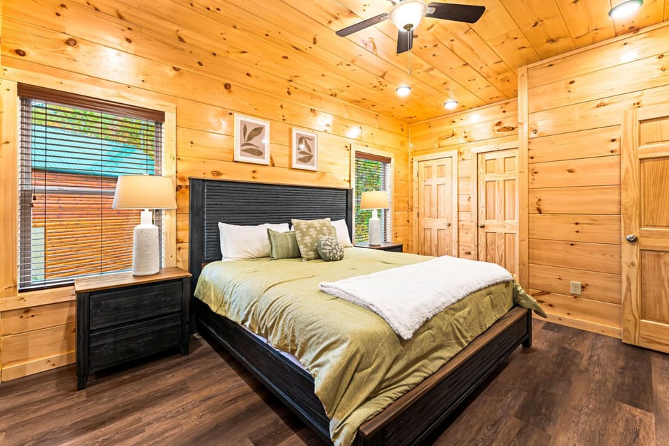 Spacious king bedroom with stylish cabin décor, warm lighting, and calming rustic charm. Ideal for couples and relaxing vacation stays.