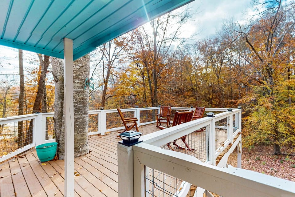 Spacious deck with wooden rocking chairs overlooking the surrounding trees.