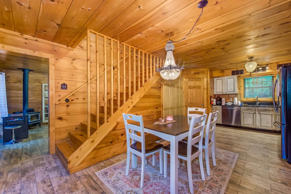 Enjoy meals under a chic chandelier in this warm, wood-paneled retreat!