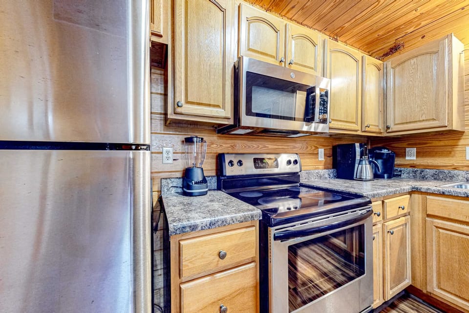 Whip up delicious meals in this fully equipped kitchen with sleek appliances and warm wood accents!