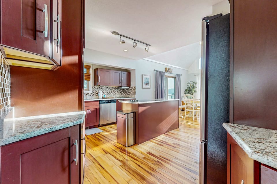 Sunlit space featuring modern appliances and gleaming wooden floors for culinary adventures!