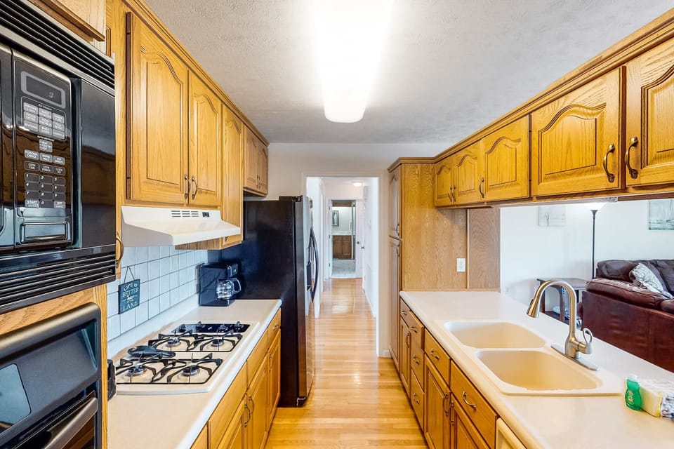 Kitchen oasis awaits. And, enjoy cooking with a spacious layout, sleek appliances, and warm wooden cabinetry!