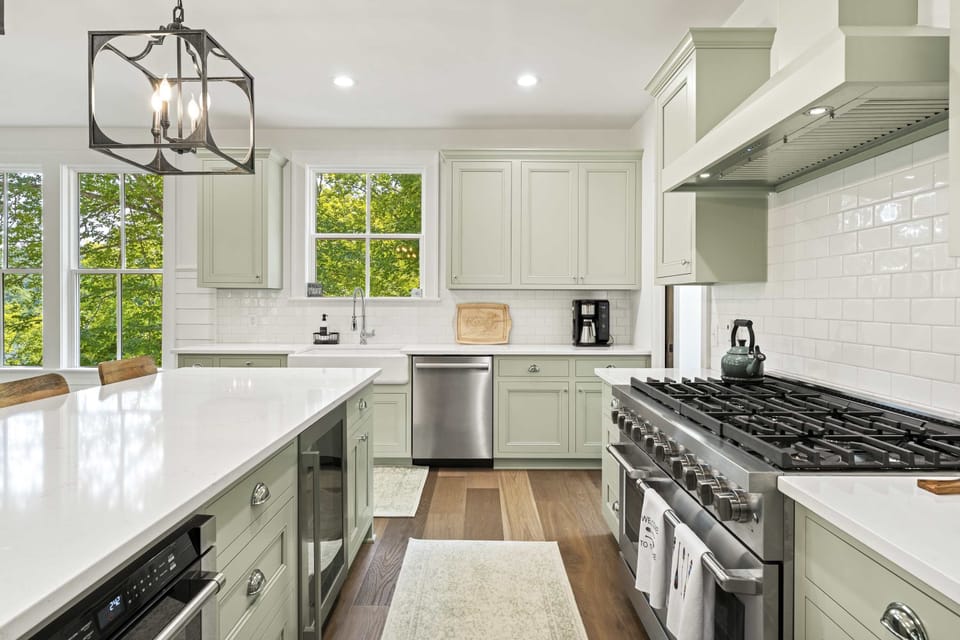 Fully stocked gourmet kitchen with oversized island, gas range, custom cabinetry, and modern appliances. Ideal for family meals, group cooking, and lake house entertaining.