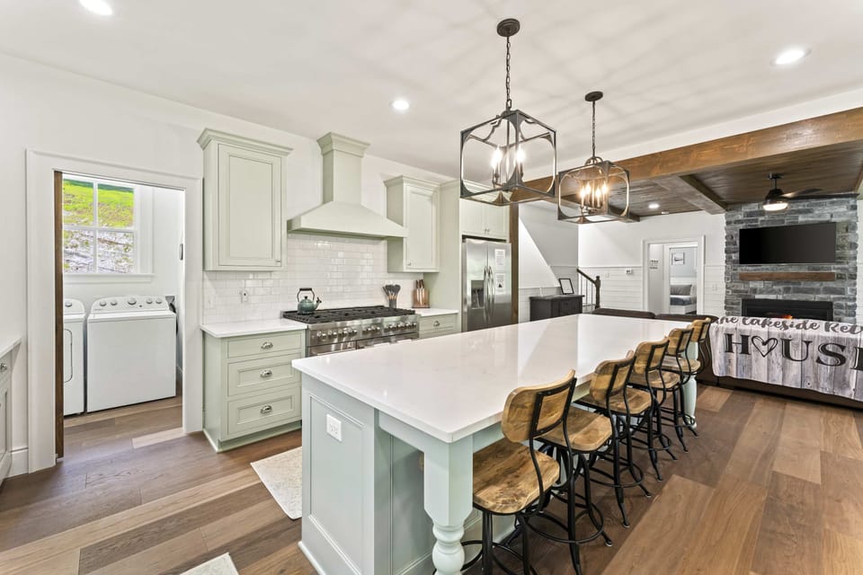 Massive kitchen island with bar seating, pendant lighting, and open sightless to the living room. 