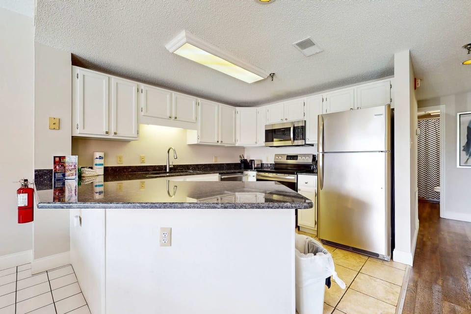 Culinary adventures await in this fully equipped kitchen with sleek appliances and ample counter space!