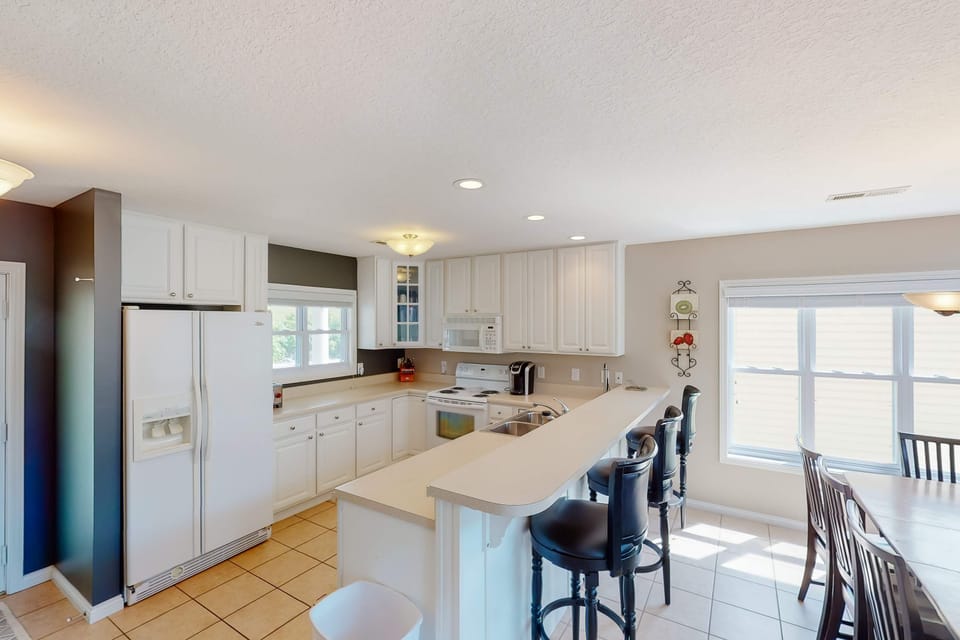 Bright, fully equipped kitchen with ample counter space and bar seating. Everything you need for cooking, snacks, and entertaining.