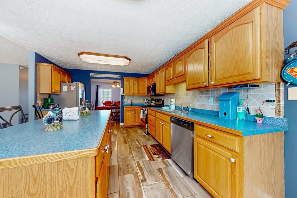 Charming kitchen awaits. Delight in vibrant blue accents and ample space for culinary adventures!