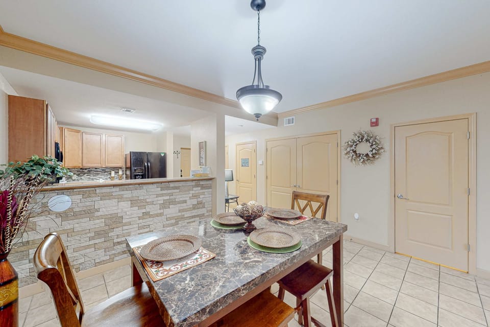 Dining area with table seating and open kitchen pass-through. Perfect for family meals and group stays.