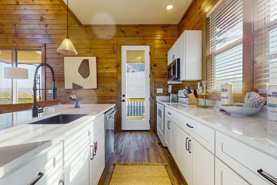 This bright, airy kitchen opens directly to the deck, blending indoor-outdoor living. Perfect for morning coffee, lake views, and Smoky Mountain cabin stays.
