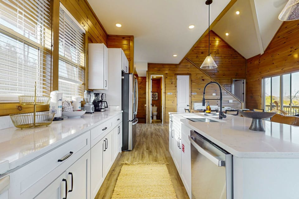 Cook with ease in this fully stocked modern kitchen with stainless steel appliances, large island seating, and cabin charm. Perfect for group stays, family meals, and extended vacations.