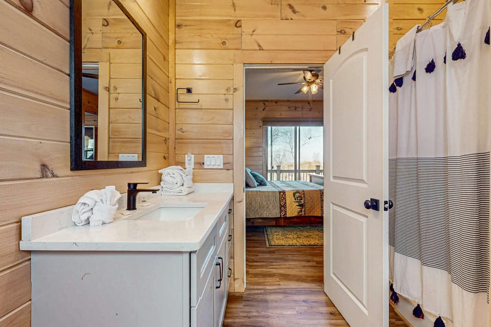 Bathroom retreat awaits. A stylish vanity with mountain views, fresh towels, and a touch of rustic charm!