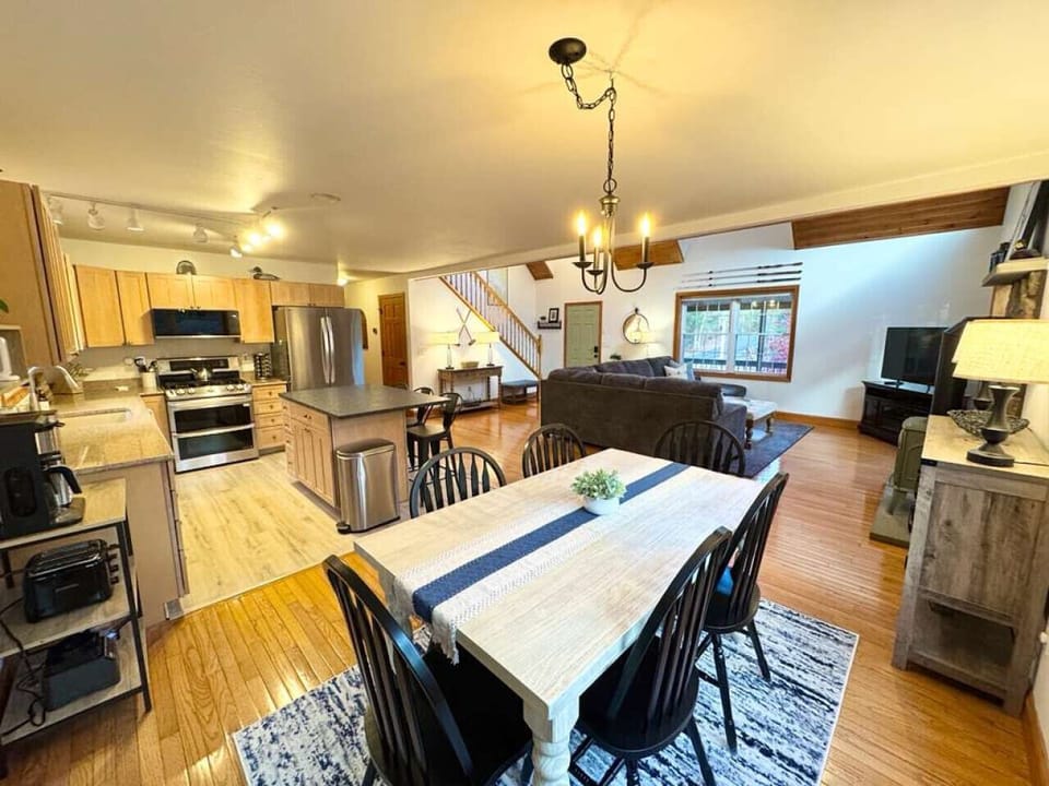 Fully stocked open kitchen with modern appliances and a large dining table for group meals.