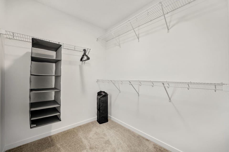Walk-in closet featuring wire shelving and clothing rod organization