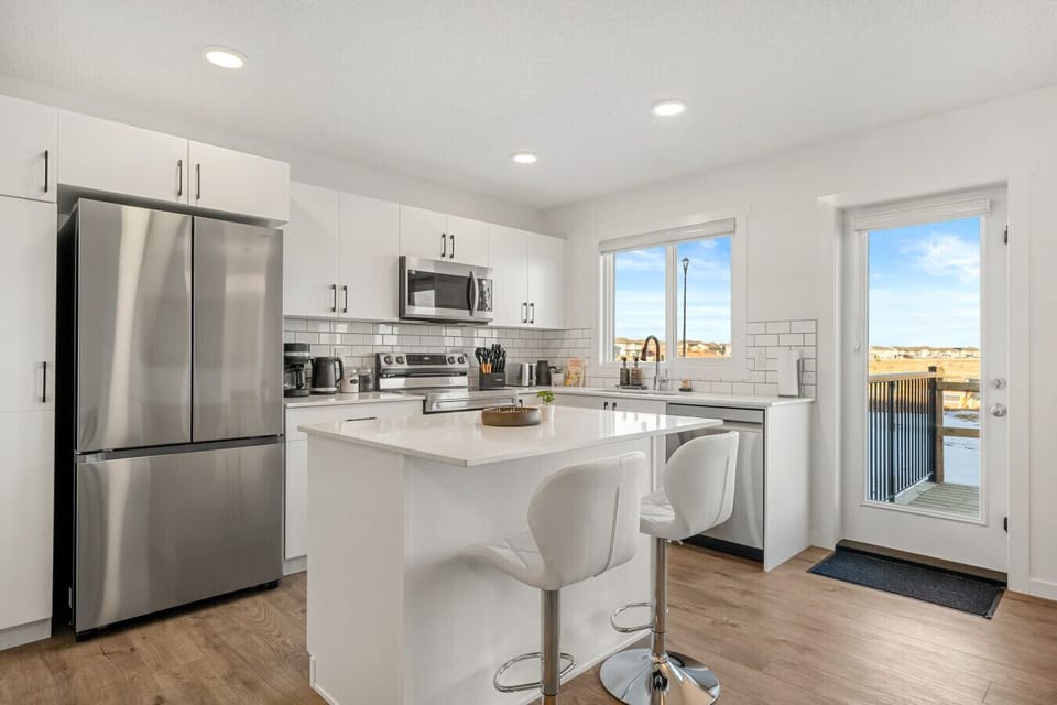 Well-equipped kitchen with stainless steel appliances, island, and patio access