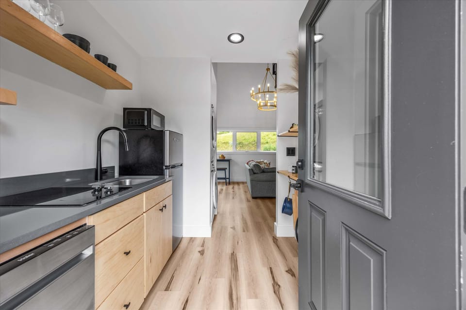 Cozy kitchen view leading into a living space with natural light and wood flooring.