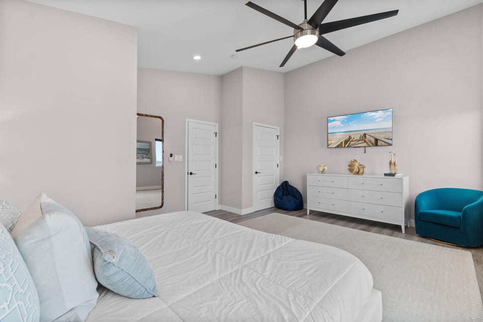Drift off in your serene bedroom sanctuary, where coastal blues meet crisp whites and gentle ceiling fan breezes keep you perfectly comfortable.