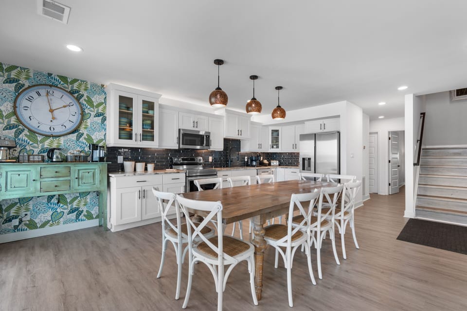 Gather your group around this spacious dining table in a bright, open kitchen. With ample seating and modern amenities at your fingertips, meal prep becomes a shared experience.