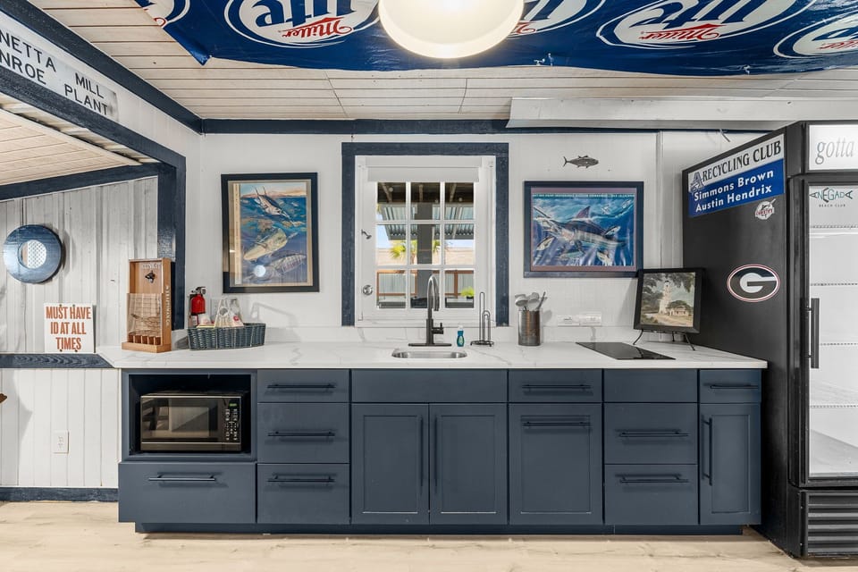 Modern kitchen with blue cabinetry and a window view.