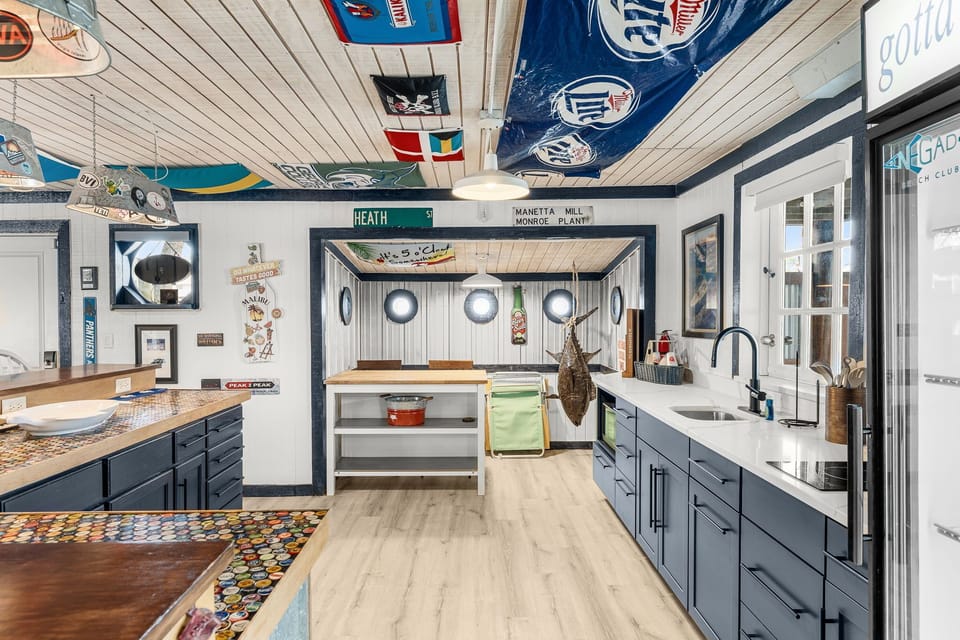 Coastal-themed kitchen with navy cabinetry and nautical decor.