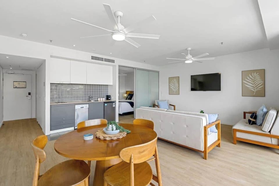 The round timber dining setting sits beside the living area, providing a warm place to enjoy simple meals prepared in the adjacent kitchenette.