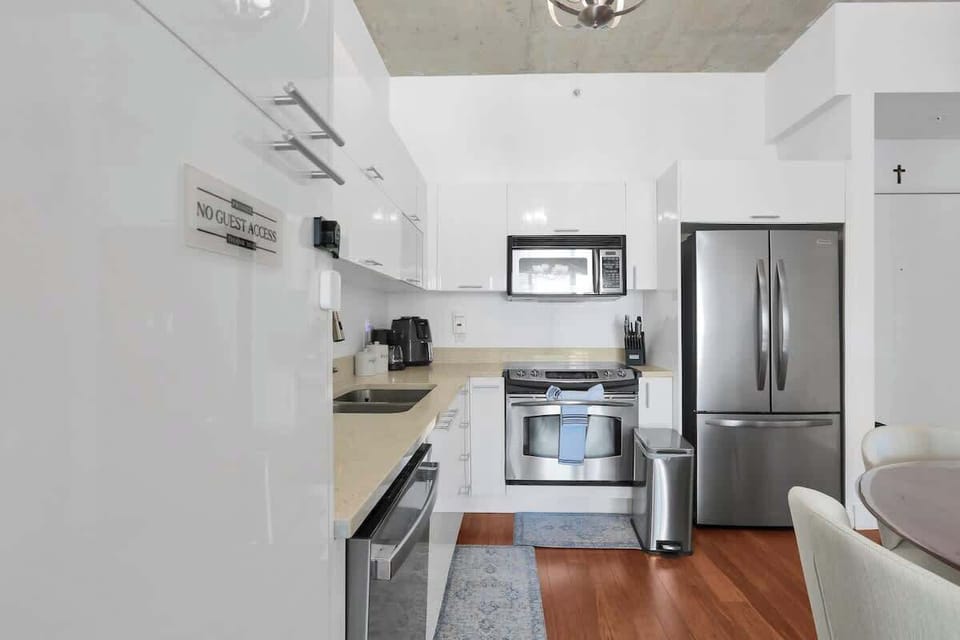 Fully equipped kitchen with large refrigerator, air fryer, microwave, coffee maker, oven, complete tableware, utensils, cups, pots, and pans.