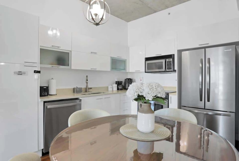 Fully equipped kitchen with large refrigerator, air fryer, microwave, coffee maker, oven, complete tableware, utensils, cups, pots, and pans.