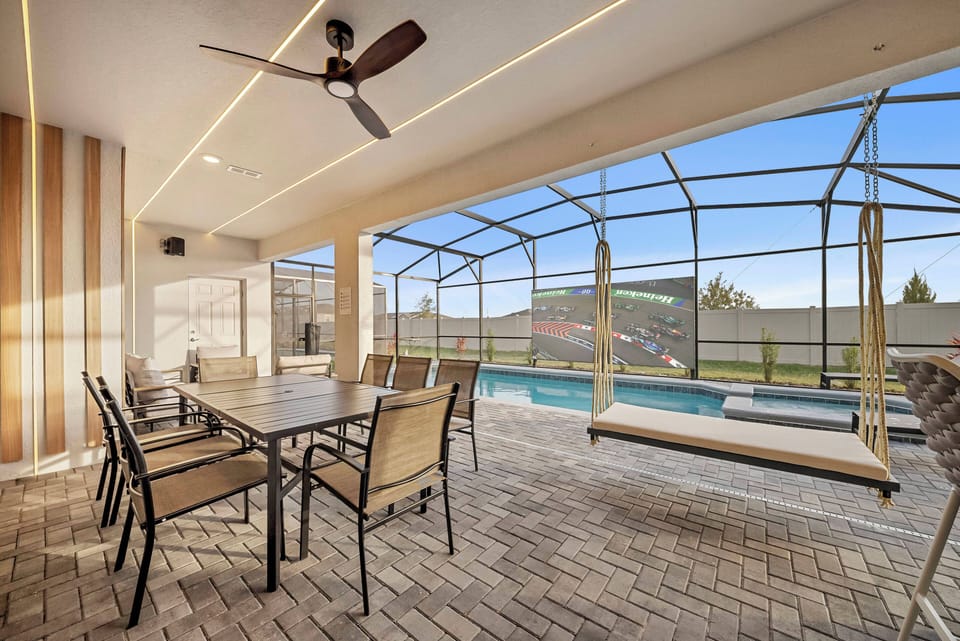 Enjoy a stylish outdoor dining area with a sleek metal table and comfy chairs, ideal for sunny meals. The inviting pool sparkles nearby, all within a spacious screened enclosure that provides protection and stunning views.
