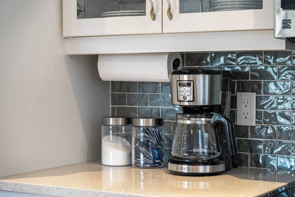 Full kitchen with a drip coffee maker, kettle, and all essentials (coffee grounds, sugar, tea, ketchup, mustard & relish.)
