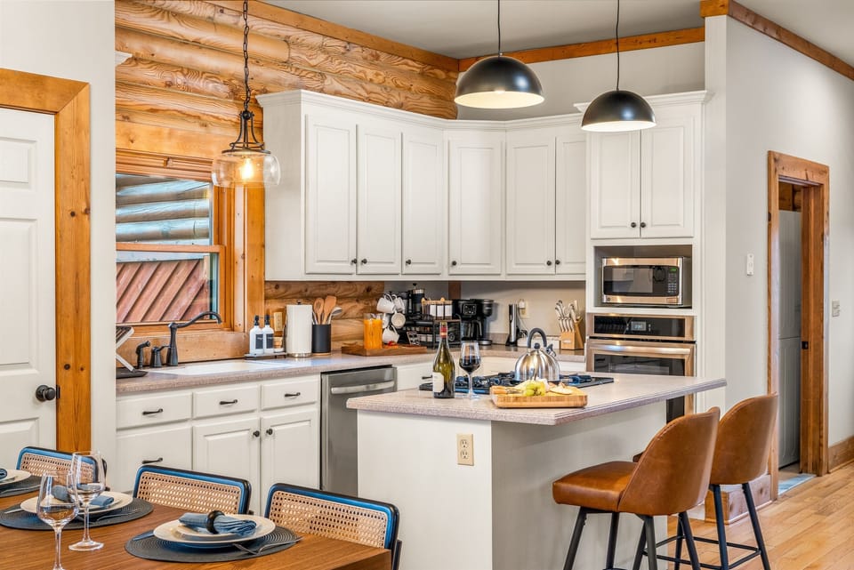 Gather for meals in the dining area with rustic cabin charm, plenty of seating, and natural light pouring in from the windows.