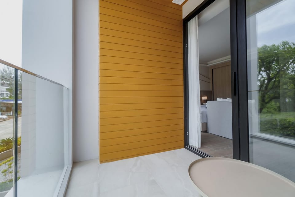 Private balcony connected to the bedroom with outdoor seating and green surroundings.