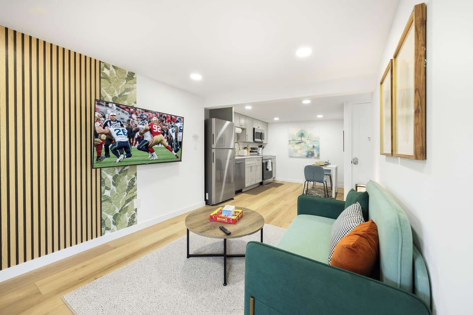 Open-concept living space with a cozy couch, large TV, and a beautifully designed kitchen. Perfect for relaxing after a day of exploring!