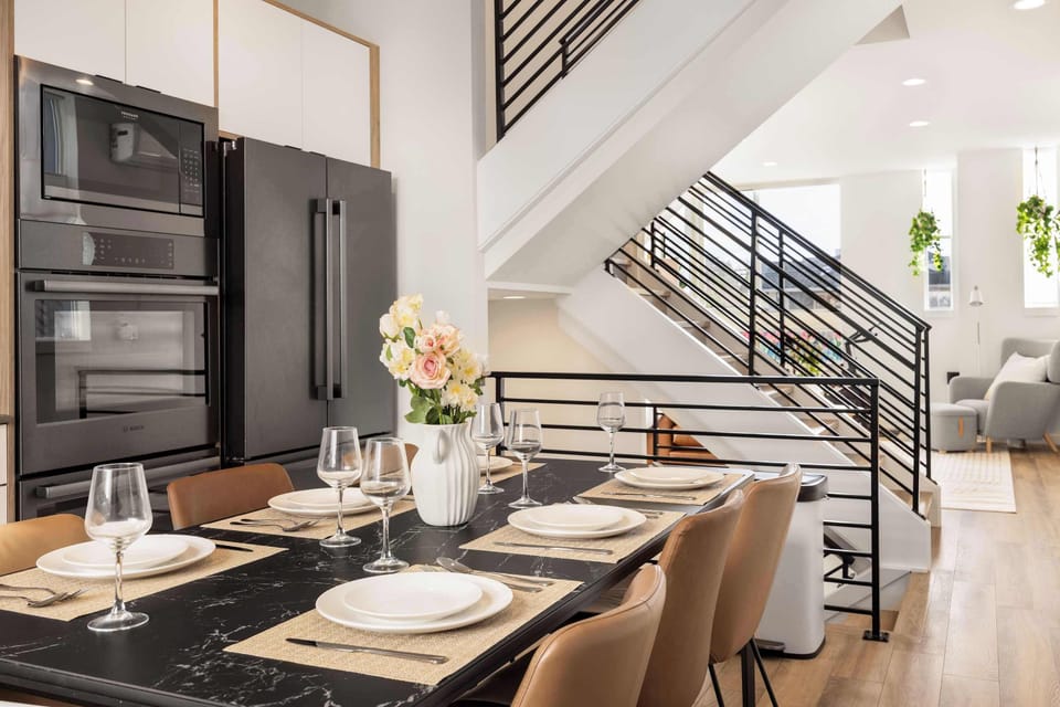 A modern dining setup with seating for six, perfect for shared meals. Sleek appliances and elegant décor make cooking feel effortless.