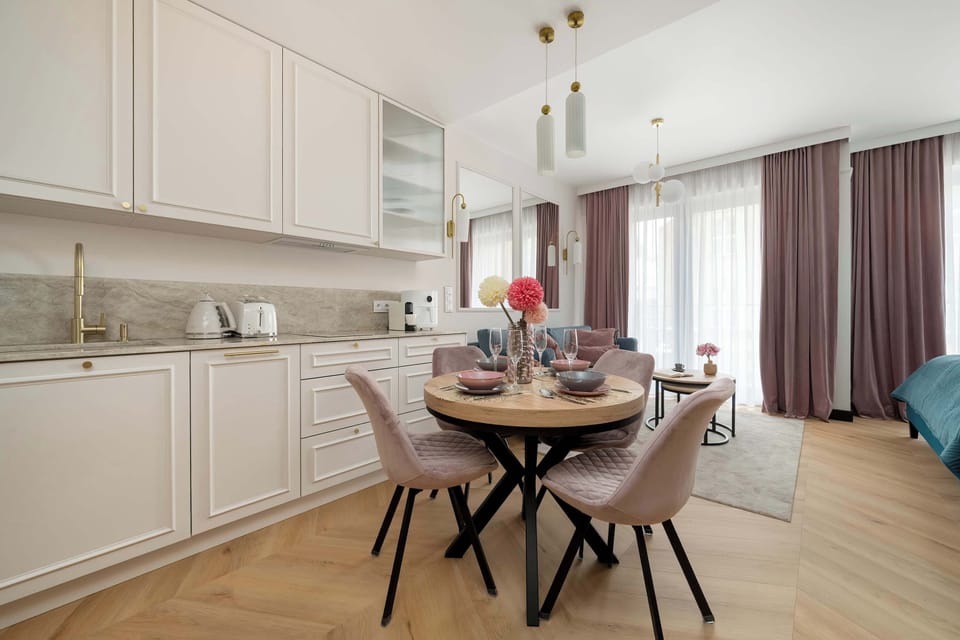 Kitchenette and dining area within the studio, with a round table prepared for four.