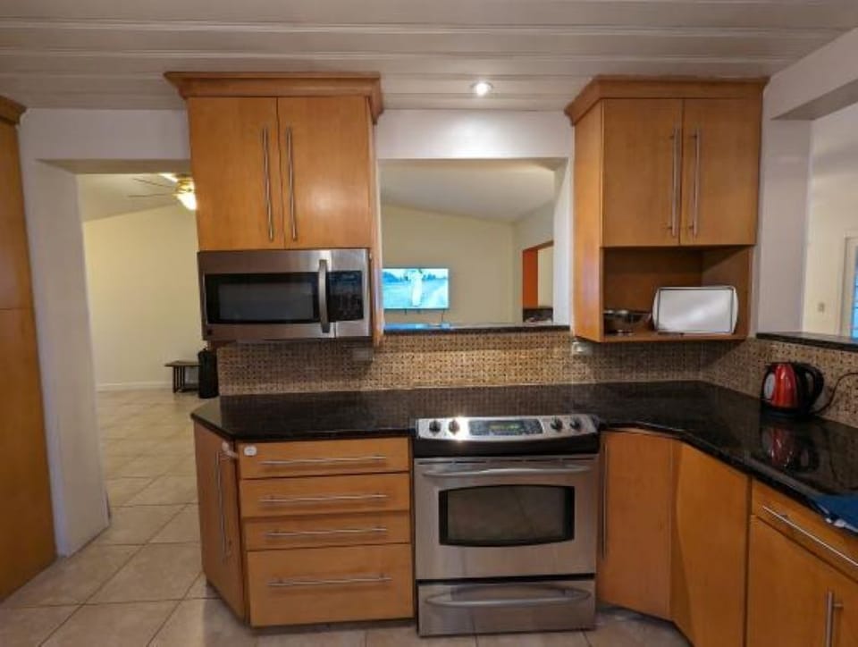Kitchen with view of stove and microwave, overlooking living room 1