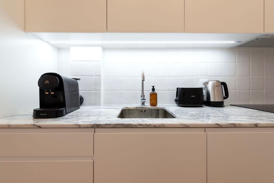 A minimalist kitchenette with premium finishes, enhanced by soft lighting that highlights its immaculate countertops.

#MinimalistDesign #PremiumFinishes #ModernKitchenette #DesignDetails
