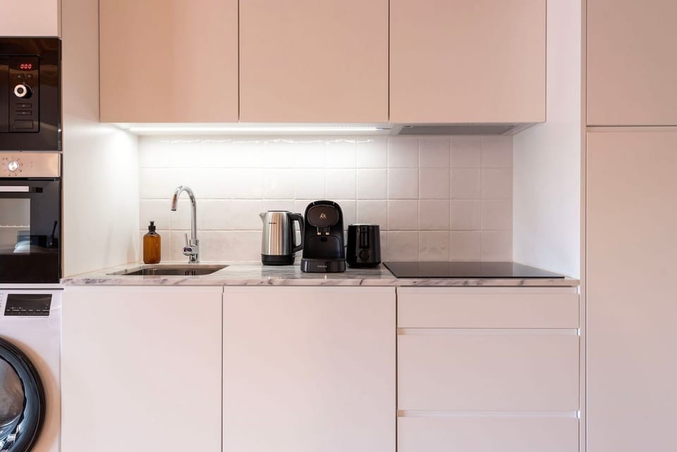 The kitchenette features sleek, high-end appliances and ample counter space, stocked with all the essentials, from cookware to utensils.