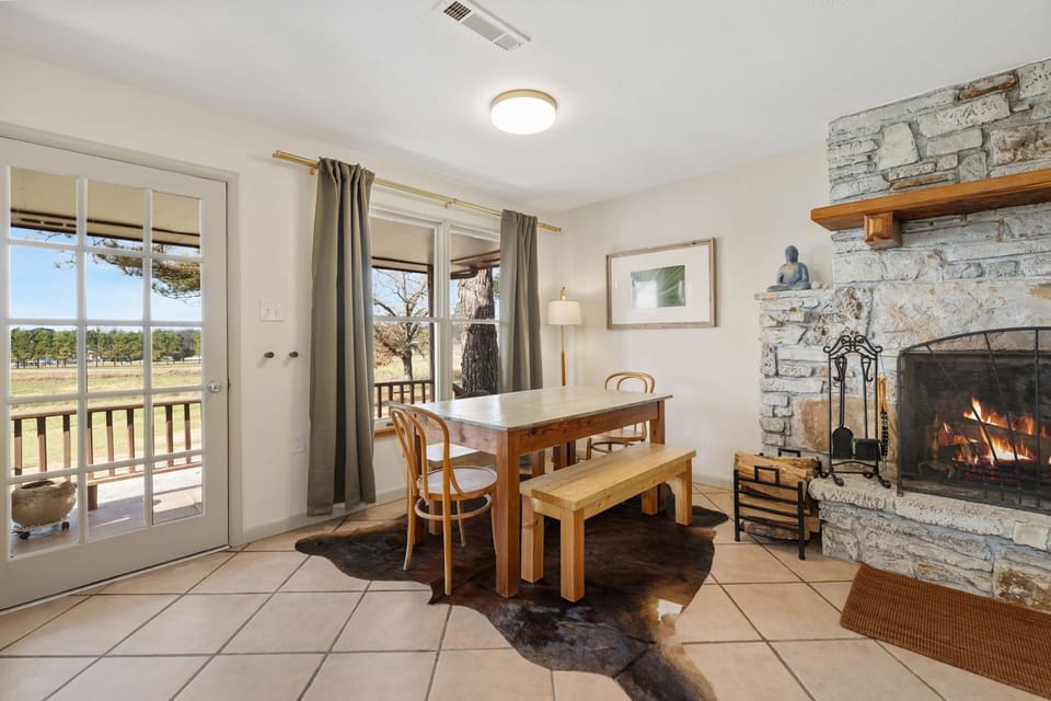 The living room has seating, a cozy natural fireplace, and a dining table for 6. 