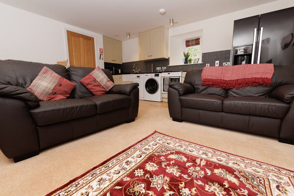 Open-plan living area with sofas and kitchen
