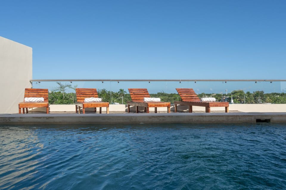 Rooftop pool with sunbeds and open-sky views for relaxing.
