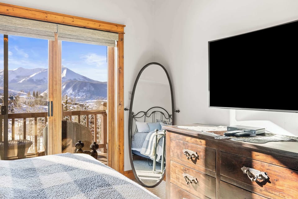 【Primary Bedroom】Wide angle — wall TV and mountain light through the window