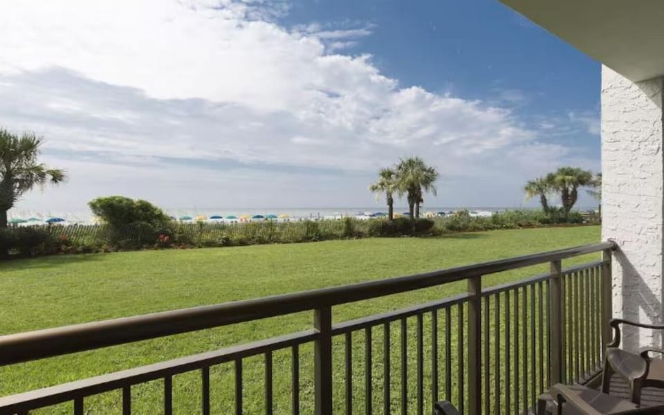 Breathe in salty air while overlooking palms and green grounds.