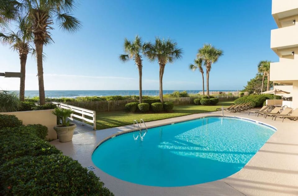 Soak in sunshine beside the oceanfront pool and palms.