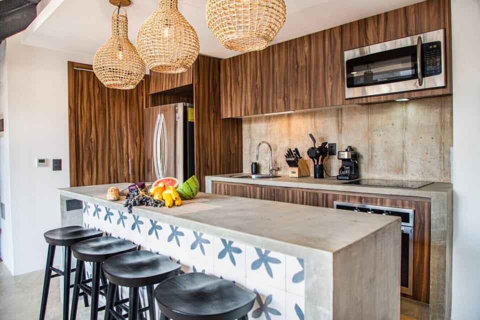 Prepare your favorite meals in a stylish modern kitchen featuring premium appliances, ample counter space, artisan lighting, and a welcoming dining area.