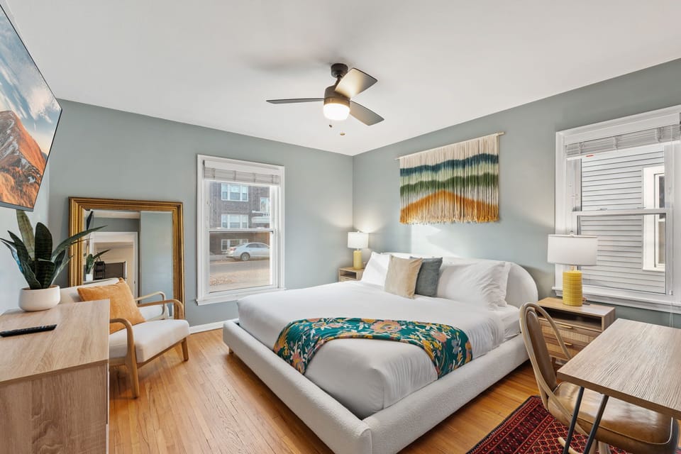 Your stylish bedroom sanctuary features calming sage walls, warm hardwood floors, and thoughtful touches like vibrant artwork to ensure peaceful nights.