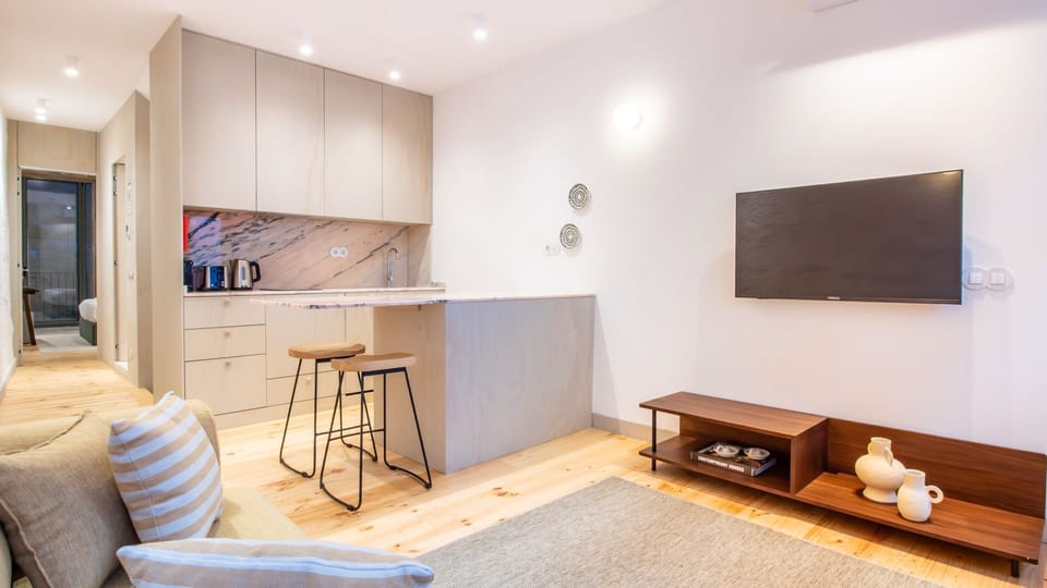 Open-plan living room with smart TV and curated décor, perfect for unwinding after exploring the city. #AirbnbPlusVibes #PortoApartment #StylishStay