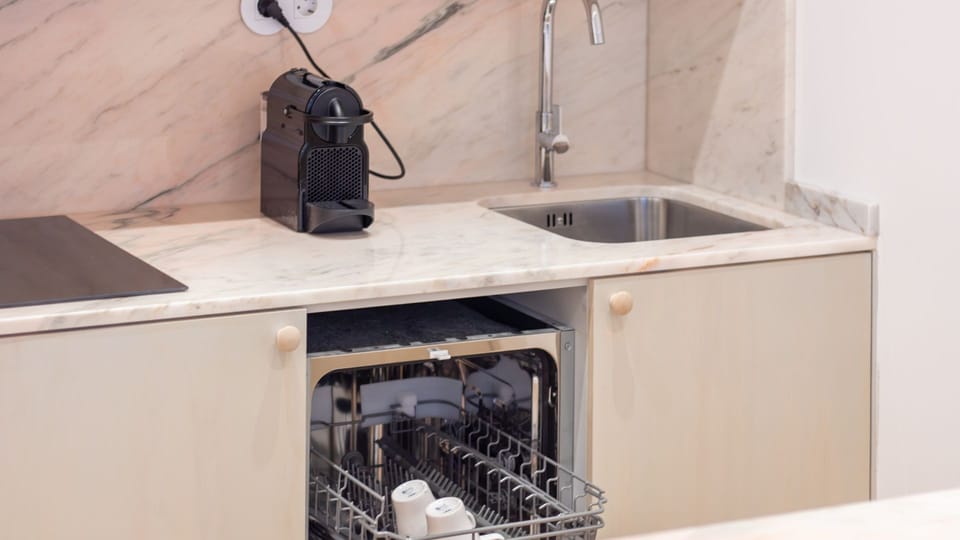 Modern kitchen with dishwasher and induction hob — designed for better stays. #ExtendedStay #FunctionalDesign #PortoAirbnb