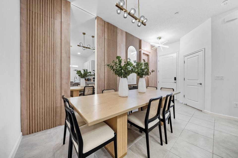 Experience a warm and contemporary atmosphere in our stylish dining area, featuring a sleek wooden table and modern black chairs. Enjoy relaxed meals and gatherings with loved ones under soft lighting and natural textures.