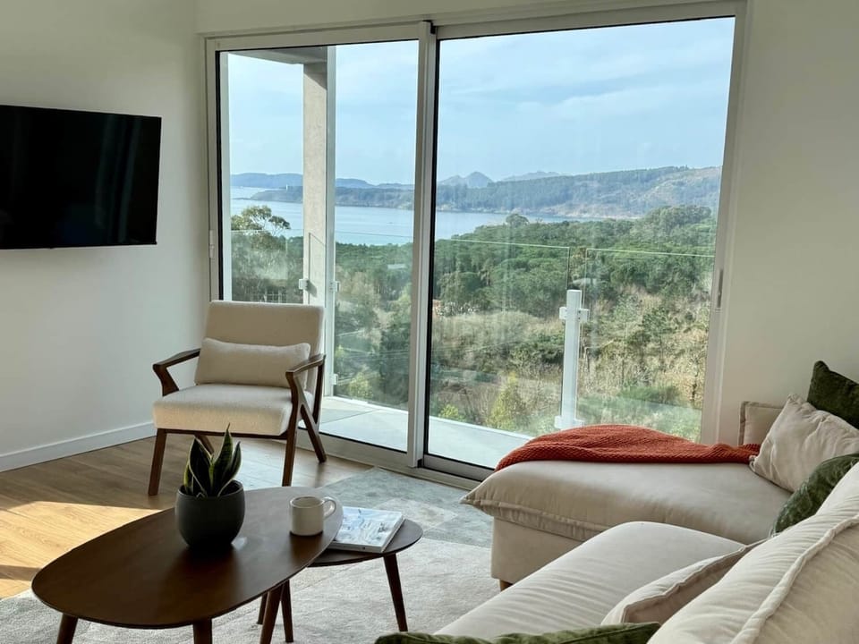 Zona de salón luminosa con dos balcones con vistas a la ría de Vigo